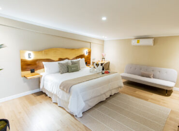 "Suite moderna y luminosa en Los Abetos Boutique Hotel con cama king y zona de descanso"