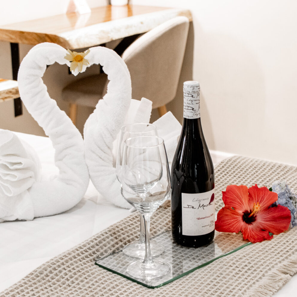 "Escapada Romántica: Habitación Decorada con Vino y Flores"