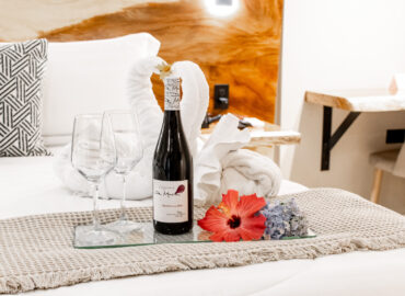 "Detalle romántico con vino y copas en la cama de Los Abetos Boutique Hotel"