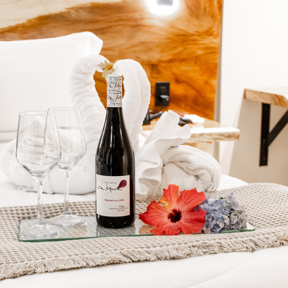 "Detalle romántico con vino y copas en la cama de Los Abetos Boutique Hotel"